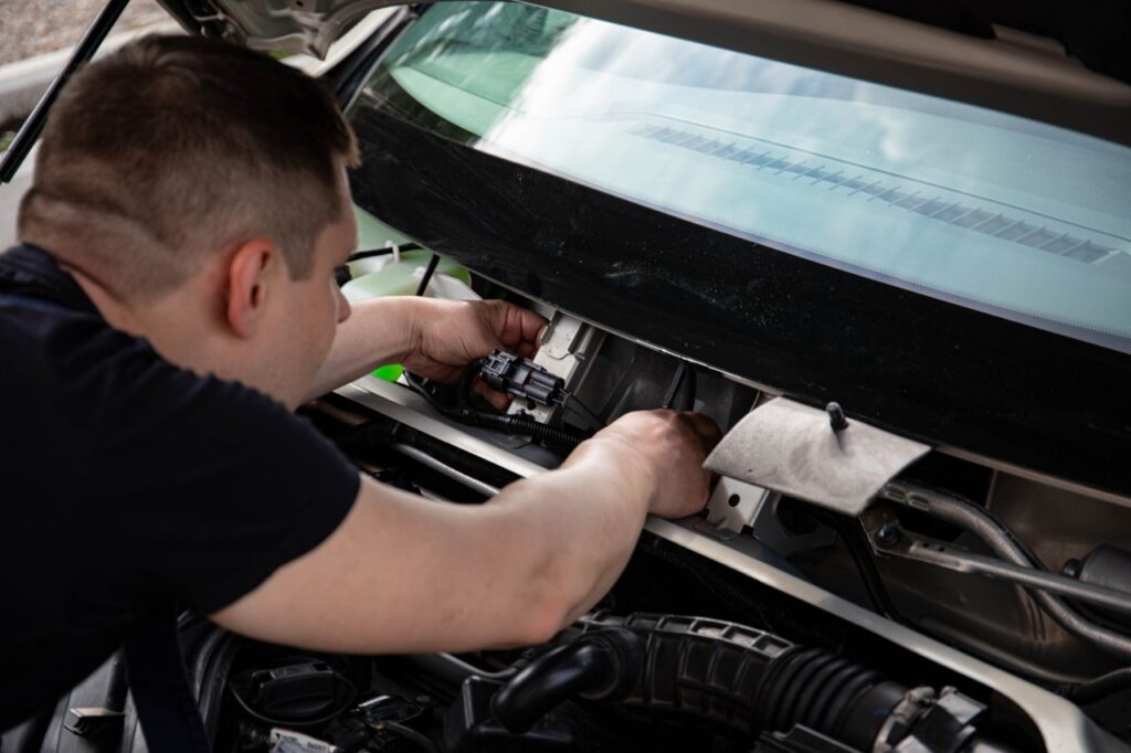 Mastering the First Impression: Your intriguing post title goes here A mechanic working on car engine repairs inside a workshop setting.